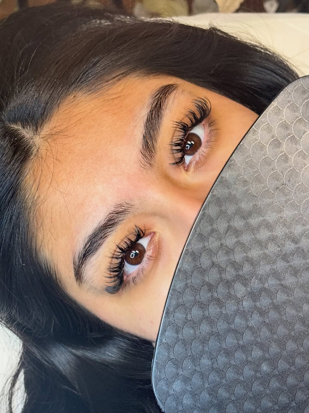 Close-up of a full, wispy lash set on dark brown eyes, done by Lincy