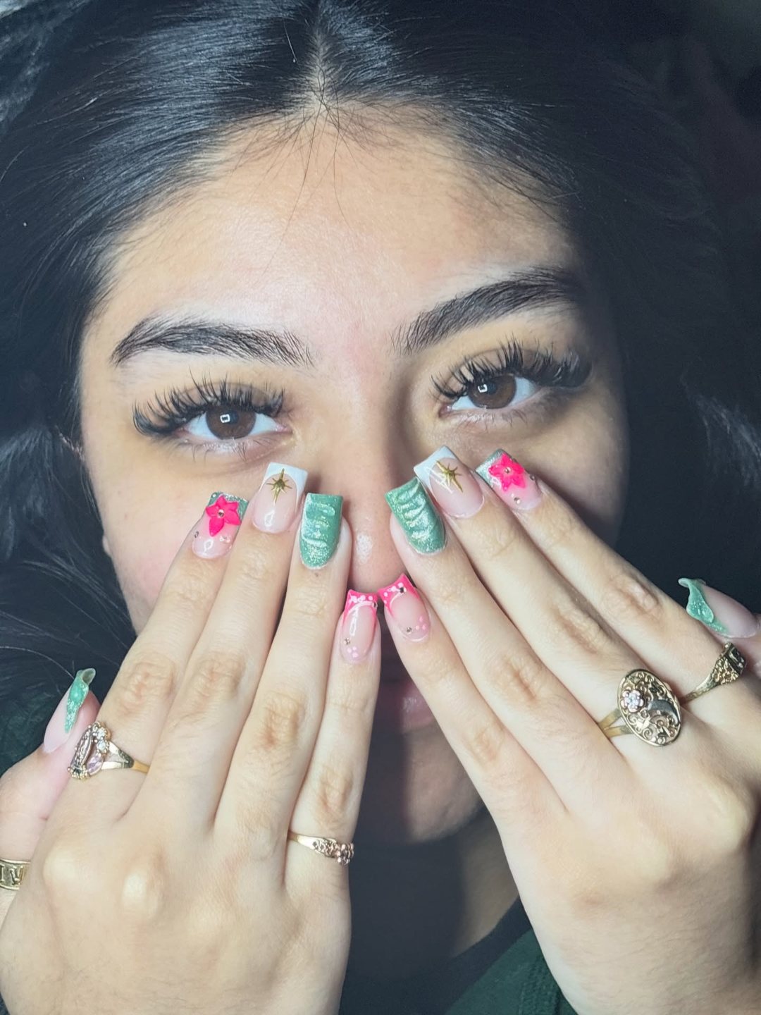 Client covering her nose with decorated nails, showing a full, wispy lash set